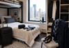 Crash Pad Life Explained for New Flight Attendants Shared crash pad room setup for new flight attendants with luggage, bunk bed, and neatly placed uniform pieces.