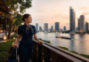Things to Do on a Layover in Bangkok for Flight Attendants: Crew-Friendly Ideas by Time and Energy Flight attendant on a Bangkok layover by the Chao Phraya riverside at sunset with skyline view and carry-on luggage