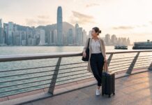 Things to Do on a Layover in Hong Kong for Flight Attendants: Crew-Friendly Ideas by Time and Energy Flight attendant on a Hong Kong layover near Victoria Harbour with skyline view and carry-on luggage