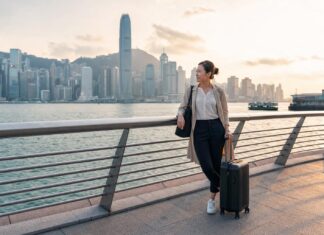 Things to Do on a Layover in Hong Kong for Flight Attendants: Crew-Friendly Ideas by Time and Energy Flight attendant on a Hong Kong layover near Victoria Harbour with skyline view and carry-on luggage